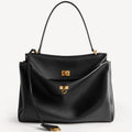 Close-up of Rodeo style slouchy medium tote bag in black with brassy gold hardware