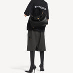 The Slouchy medium leather tote in black — styled model view