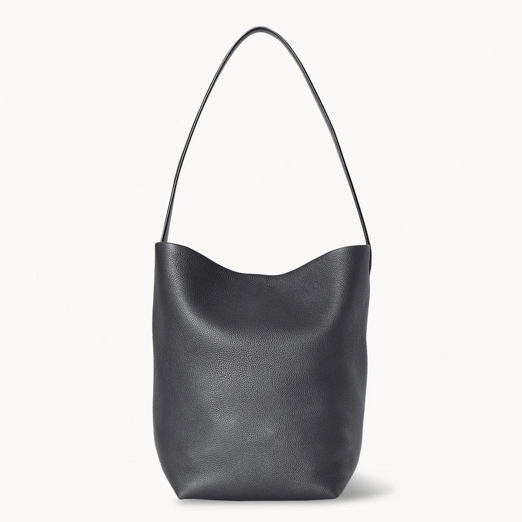 Front view of the natural grain and soft drape on a Park Tote inspired medium leather bag in black