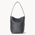 Front view of the natural grain and soft drape on a Park Tote inspired medium leather bag in black