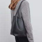 Vertical soft leather tote in black — model shot