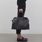 Black leather tote bag with toggle closure and side tabs