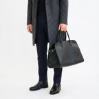 Black leather tote bag with toggle closure and side tabs