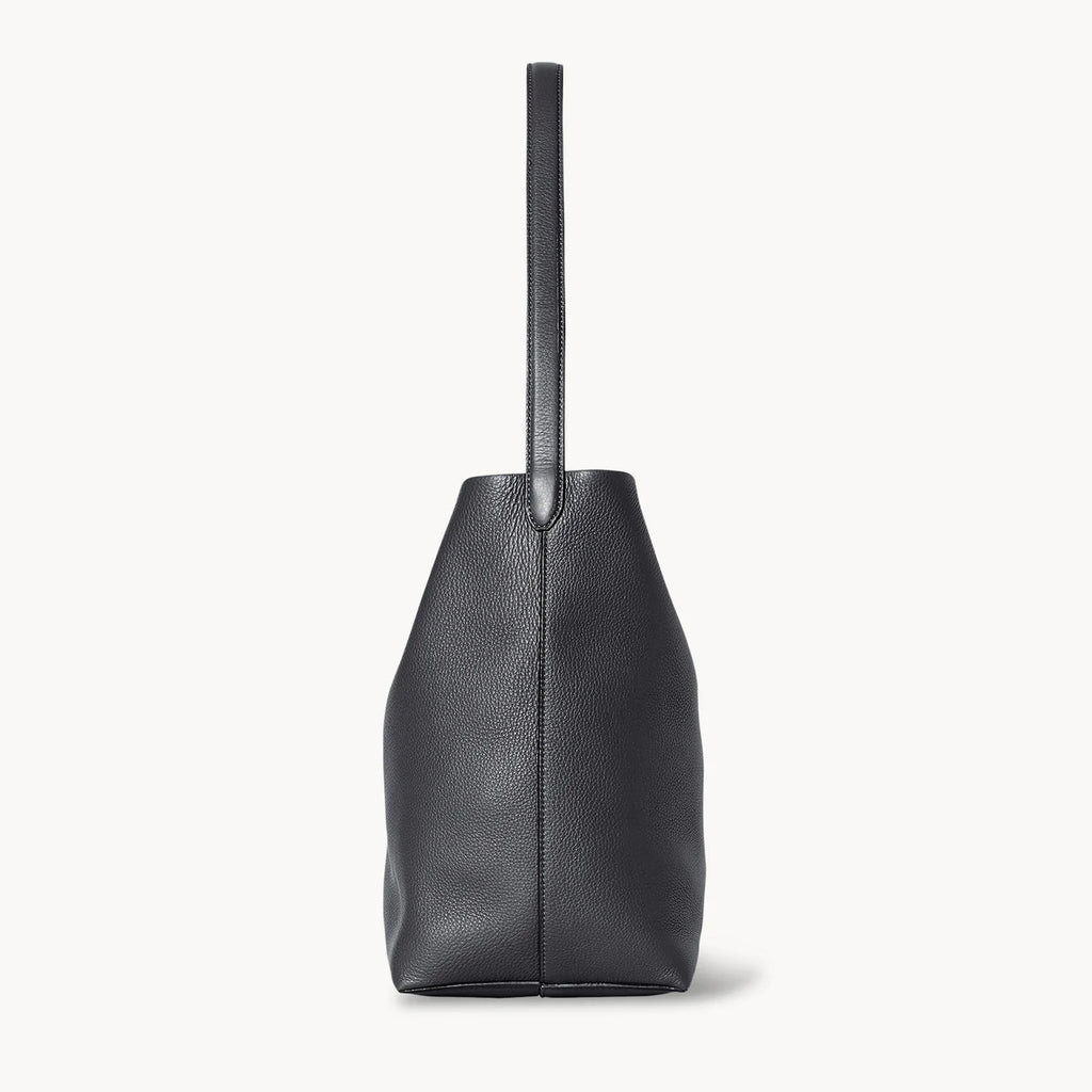 side view of natural grain and soft drape on a Park Tote inspired medium leather bag in black