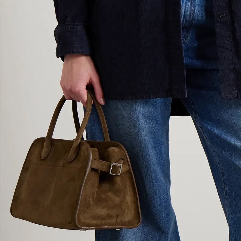 model with the Margaux 10 style suede tote bag in Coffee Brown with belted side details.