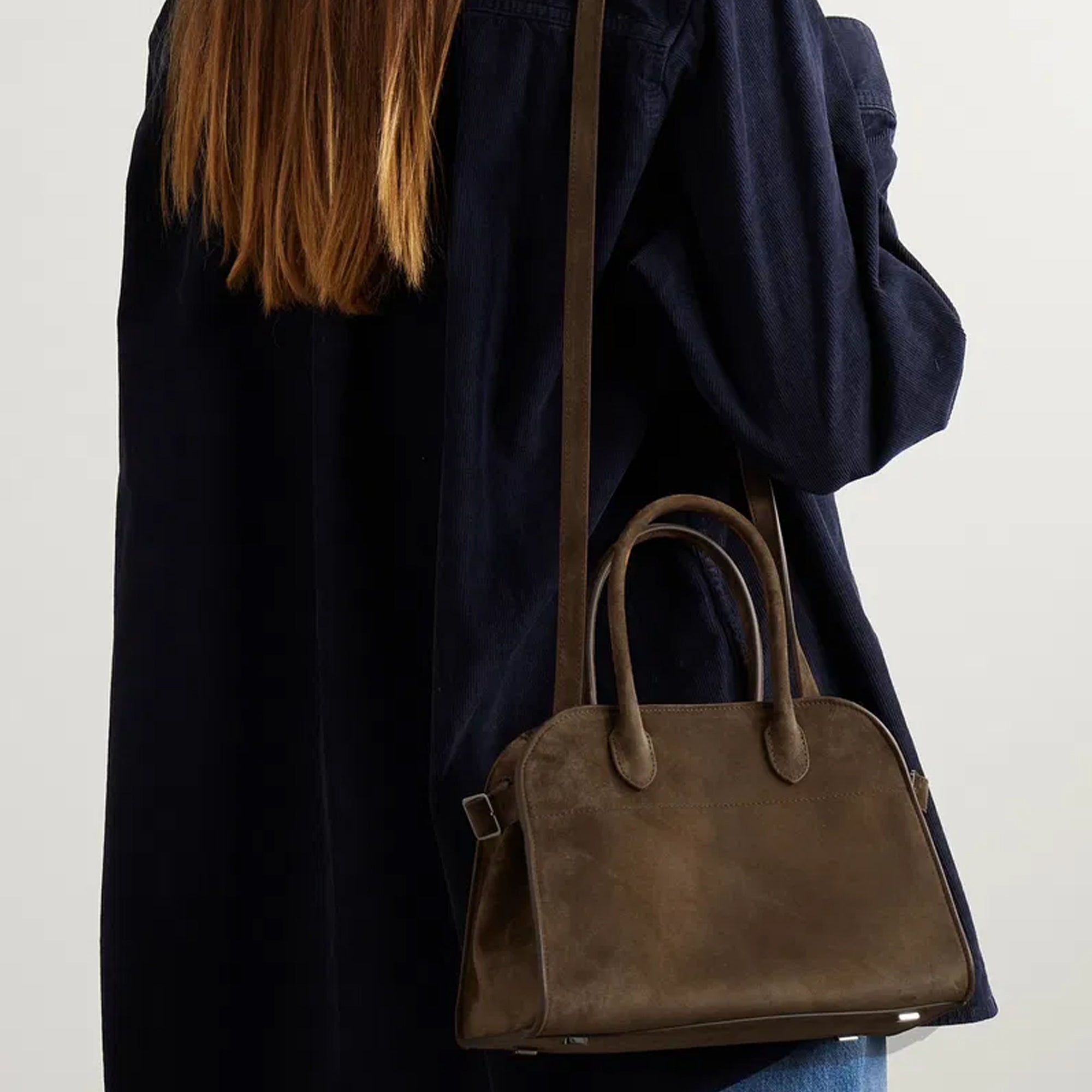 model with the Margaux 10 style suede tote bag in Coffee Brown with belted side details.