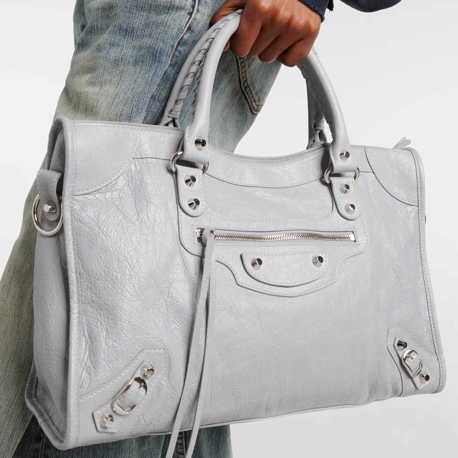 Close-Up of Silver Hardware and Tassel Zipper on Light Gray Leather Bag