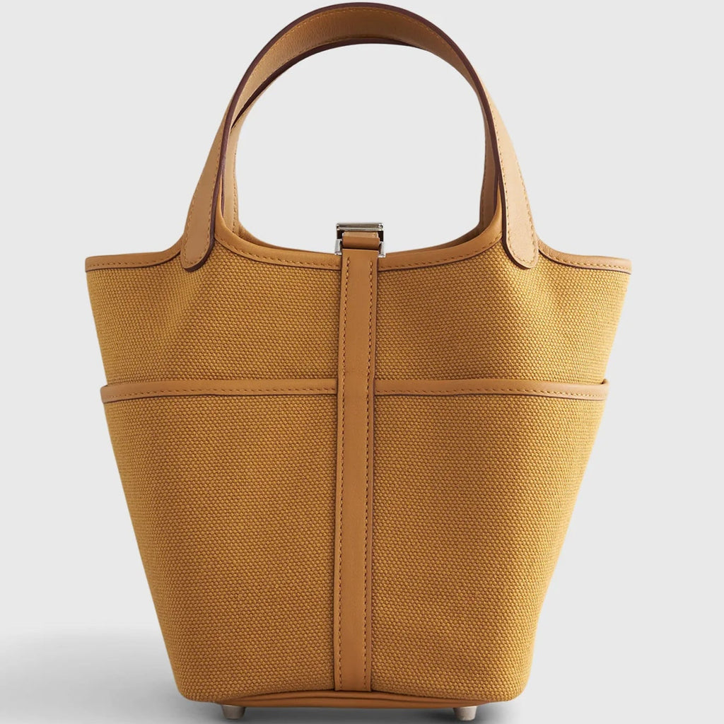Sesame Beige bucket bag with canvas-style body, vegan leather trim, top-handle, lock strap, and utility side pockets
