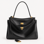 The Slouchy medium leather tote in black — close-up of brassy gold hardware