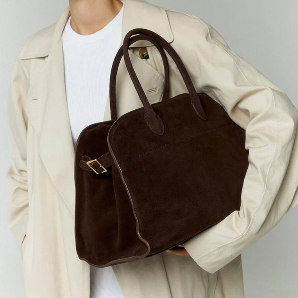 model with the large Margaux 15 style suede tote in Coffee Brown with signature belted sides.