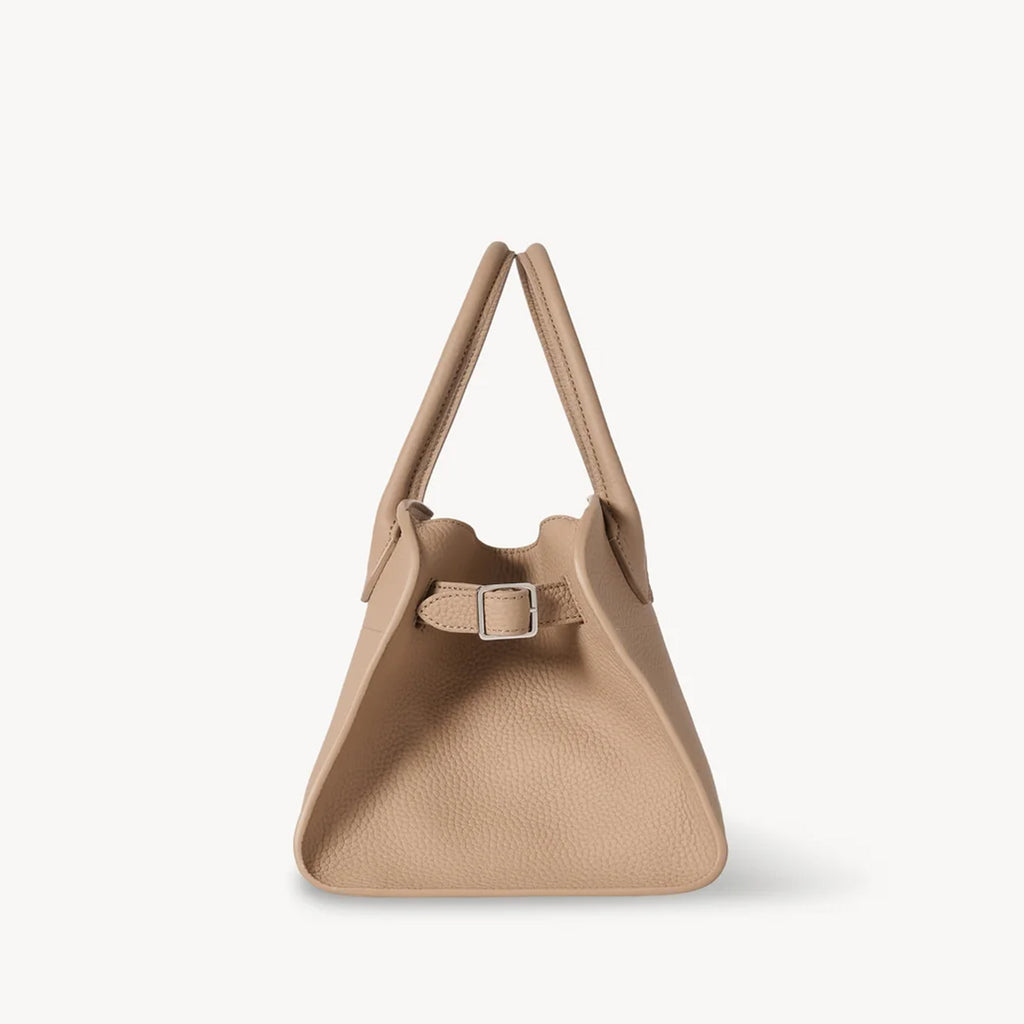 Side view of the Taupe Margaux 10 style compact structured leather tote with belted sides.