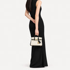 Classic Mini 20 togo leather tote in contrast black and white carried by hand, model shot