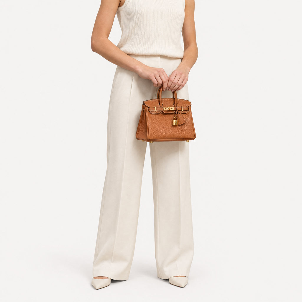 Classic Mini 20 togo leather tote in brown carried by hand, model shot
