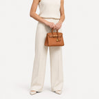 Classic Mini 20 togo leather tote in brown carried by hand, model shot
