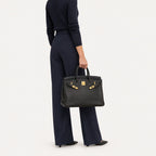 Classic 35 togo leather tote in black carried by hand, model shot