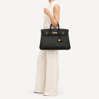 Classic 40 togo leather tote in black carried on the arm, model shot