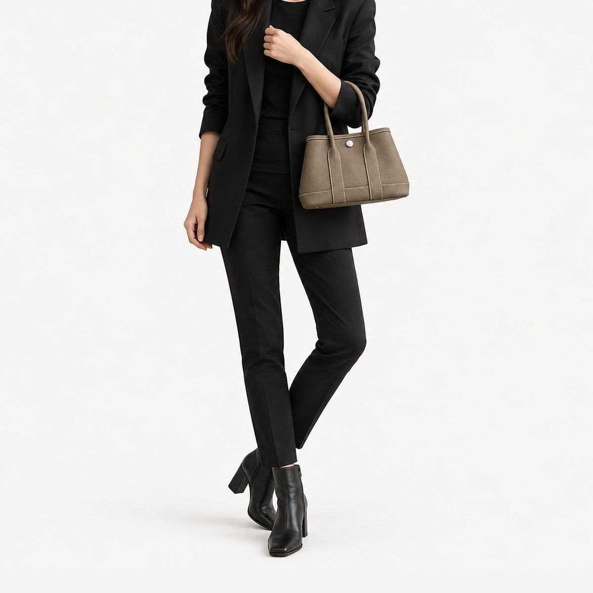 Weekday Tote Mini 23 cm open-top tote in khaki carried in the crook of the arm with a black blazer and slim trousers, model shot