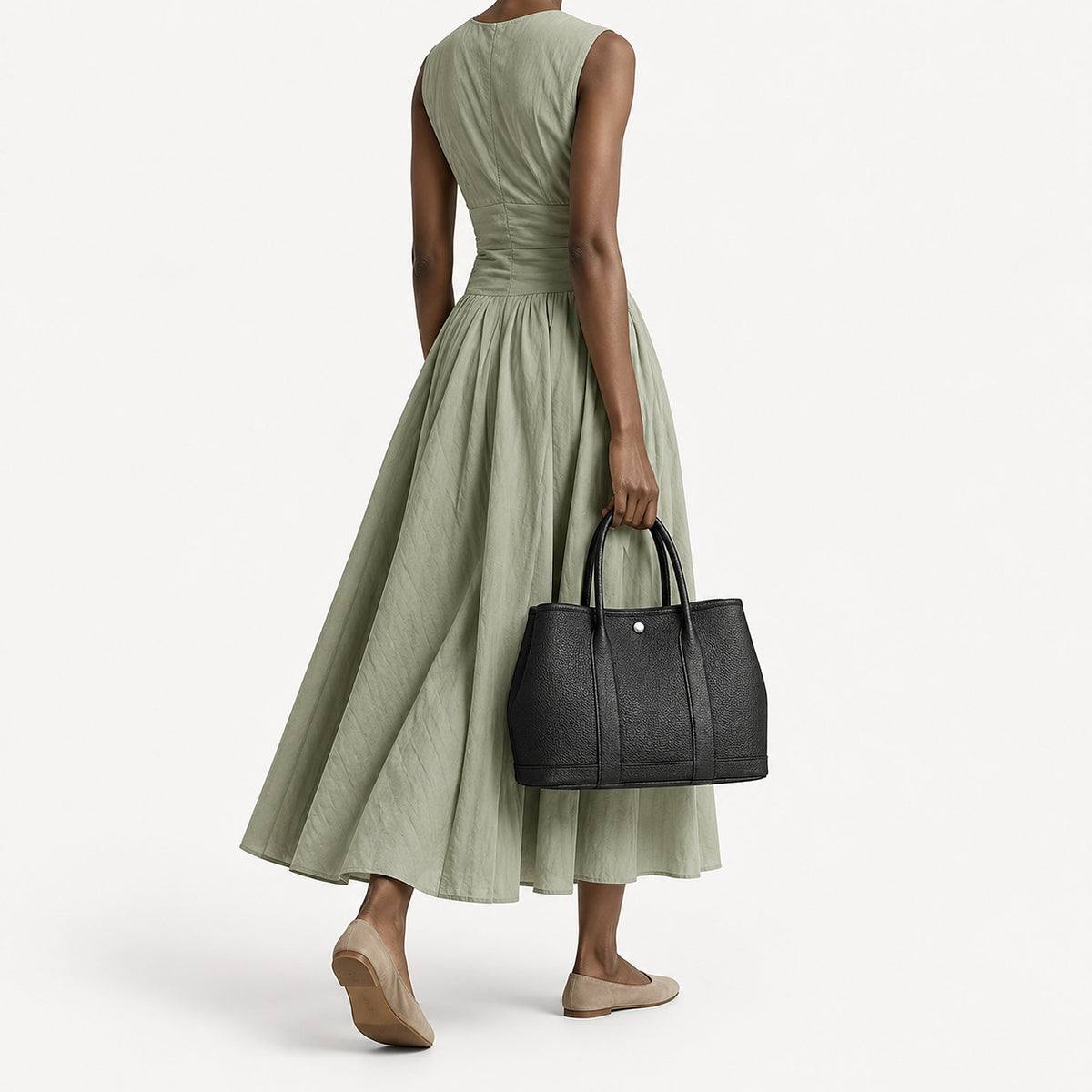 Weekday Tote Medium 30 cm open-top tote in black carried by the top handles with a sage green midi dress, model shot showing the 30 cm size on the body